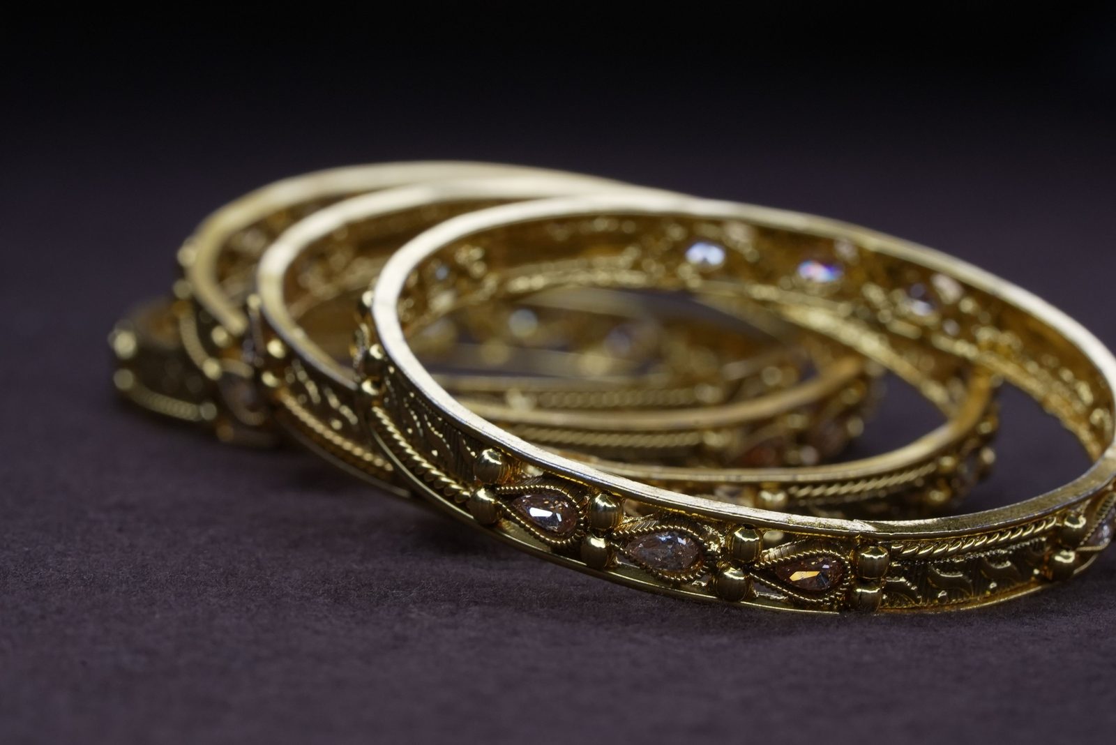 Engraved gold bangles with pear-cut stones